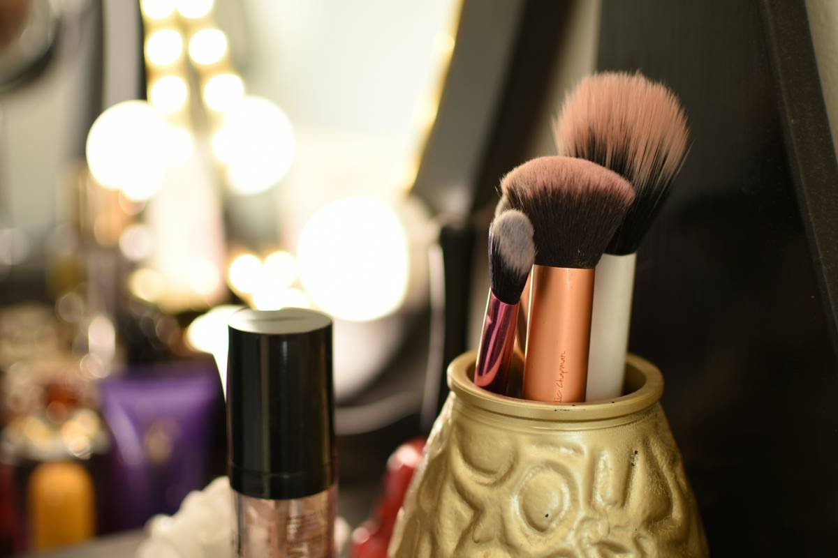 Side-by-side comparison: left side shows messy vanity with scattered makeup; right shows same space with acrylic vanity makeup organizer holding products neatly