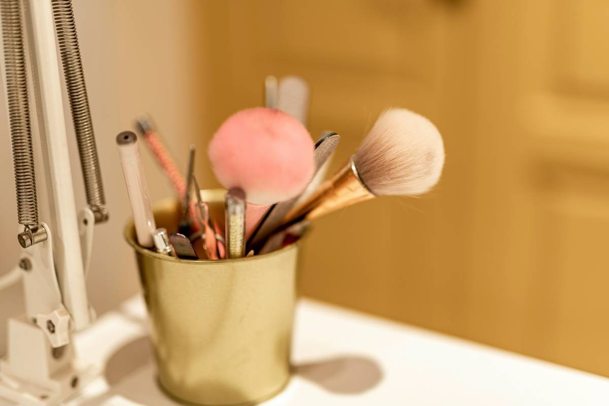 Side-by-side image: left shows chaotic makeup drawer with spilled products; right shows same drawer with clear acrylic organizer inserts neatly holding brushes, compacts, and liquids
